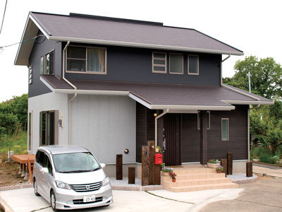 ツートンカラーの家の玄関は木目調のサイディングで温かみのある雰囲気。