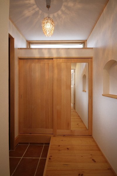 シェードが太陽のような光の模様を映し出し、玄関ホールを華やかに彩ります