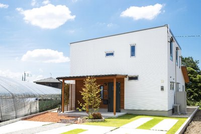 青い空と緑の芝生に映える白い壁