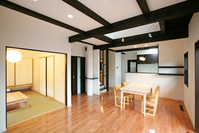 LDK。太い濃い茶の梁が白い壁を引き締めるアンティーク調の雰囲気。家族がいつも一緒に過ごす、やすらぎの空間。暗くならないように、床にはピンク色が美しいサクラ材を使用。 LDK。太い濃い茶の梁が白い壁を引き締めるアンティーク調の雰囲気。家族がいつも一緒に過ごす、やすらぎの空間。暗くならないように、床にはピンク色が美しいサクラ材を使用。