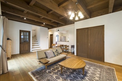 高い天井を希望されたので梁出しスタイルにしました。
ダイニングリビングは家具を最小限にとどめてスッキリした雰囲気に。キッチンは正面右にあり2階からの生活導線距離を考慮してつくりました。玄関ホール、洗面、家事室、キッチンという導線も考慮しています。