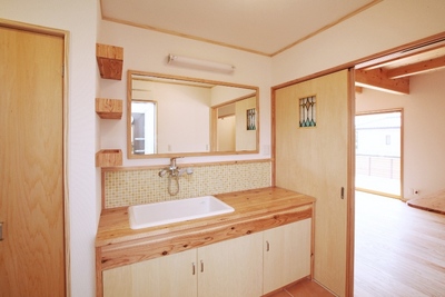 洗面脱衣室。キッチンのすぐそばで、便利な家事動線となっている。
造作の洗面台と鏡は大きく、子どもたちの朝の身支度もスムーズに。