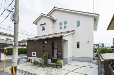 今回はやや落ち着きのある外観です。白い塗壁と落ち着きのある自然素材の板張り。正面のアイアンゲートはオリジナルデザインで我が家流です。