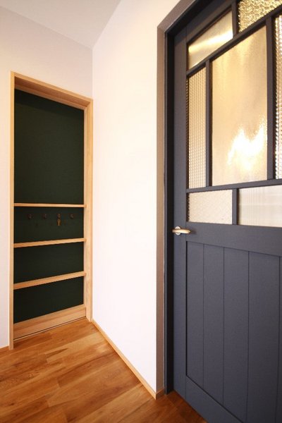 手前の青いドアは玄関ホールから続くドア。そして飾り棚のように見えますが、書斎への入り口となる引き戸です。