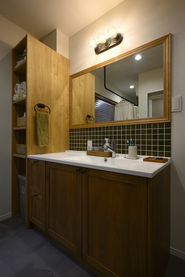 洗面脱衣所にはランドリースペースも設けました。
化粧台は無垢を使用。横には可動棚を設け収納するものによって高さを自由に変えられます。