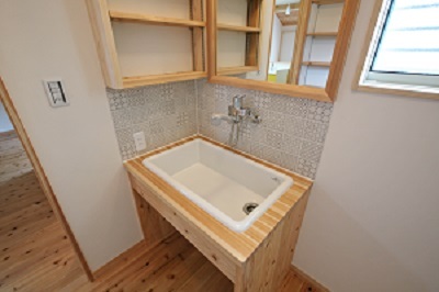 造作の洗面台にもリビングに使われていたタイルの色違いをコーディネート。