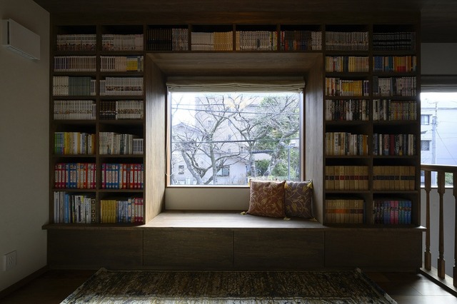 2階のホールには、造作の本棚とヌックを設けました。
真ん中のFIX窓からは、目の前にある公園の木々を眺められ、四季折々の風景を楽しむことができます。
本棚は、お持ちの本の大きさに合わせ造作しました。足元は引き出し式の収納にしています。