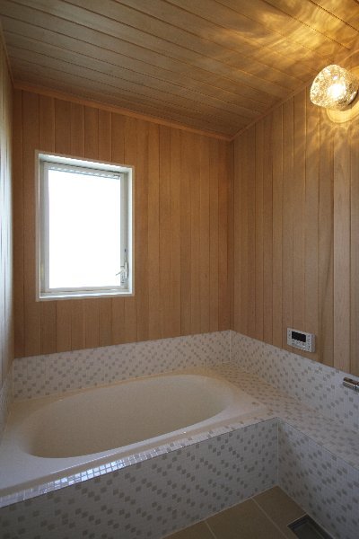 浴槽の周りはタイル貼り、壁は一面ヒバ板貼りのオリジナリティー溢れる浴室。