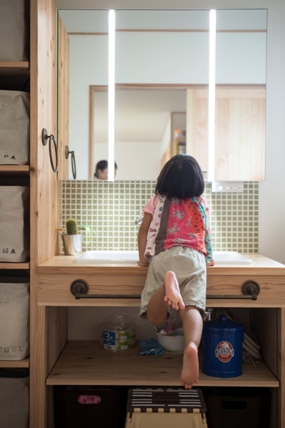 優しい表情の無垢材とモザイクタイルを使って造作した洗面台。緑色のタイルは奥様セレクト。