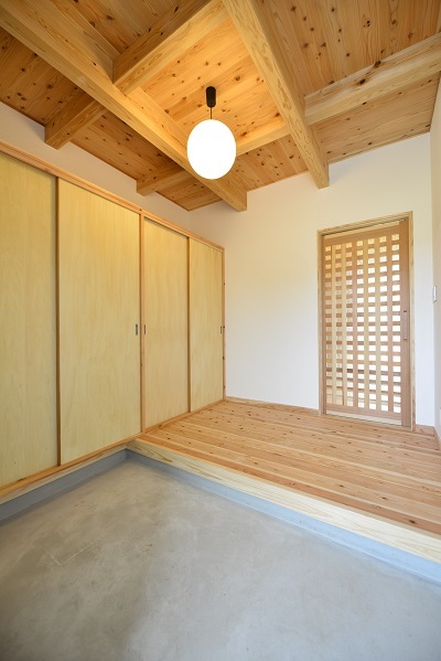 大容量の収納があるスッキリとした玄関。格子模様の造作の引戸を開けるとリビングに直結している。