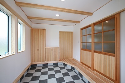 玄関から入る建具は無垢材でつくったオリジナルデザイン。市松模様のタイルがお出迎え。