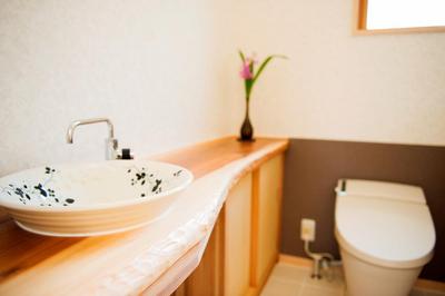 1枚板のカウンターに陶器の手洗いボウルを据えた広いトイレ。床はお手入れが楽なタイルです。 1枚板のカウンターに陶器の手洗いボウルを据えた広いトイレ。床はお手入れが楽なタイルです。