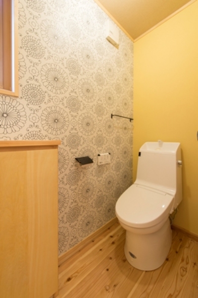 トイレはリビングからワンクッション距離を置き、洗面台スペースの先に設けました。大輪の菊柄の個性的なクロスが印象的。