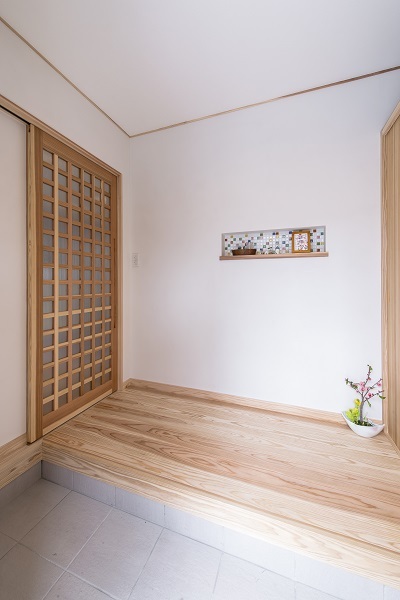 玄関から入るドアは無垢材でつくったオリジナルデザイン。ニッチに施した可愛いカラフルなタイルがお出迎え。