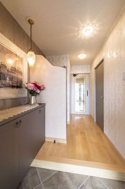 玄関は三和土をタイルへ。天井まであった袖壁は、上部をカットし漆喰で温かみをプラス。