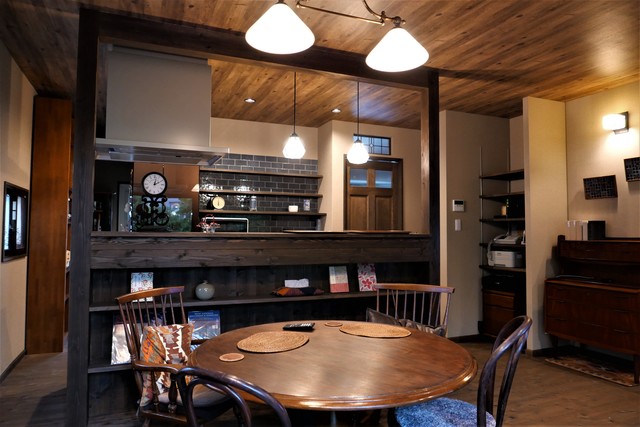 木をふんだんに取り入れた空間に夫人が探してこられたシックなタイルがフォーカルポイントになっていて、楽しみながらお選びになった照明やお持ちの家具ともぴったり合っています。カップボード横の洗面室につながるドアの上部にはステンドグラスをはめ込み、キッチン前面の飾り棚は本を立て掛けてもすべり落ちない工夫がしてあります。コンセントやキッチンのペンダント照明のレールなどが見えないようになっているのもすっきり見えるポイントです。