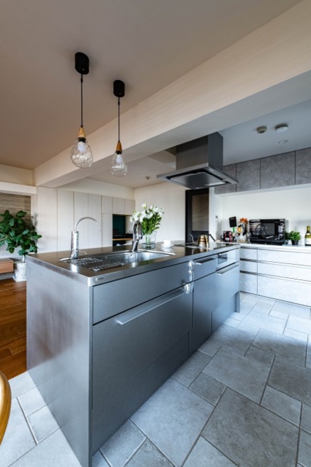 ダイニングスペースに対面していたキッチンは、90度角度を変えてLDKのほぼ真ん中に。
リクシル製のキッチンはスタイリッシュなステンレス仕様。タイルや木目の床と調和し、スパイス的な存在感をもたらしています。