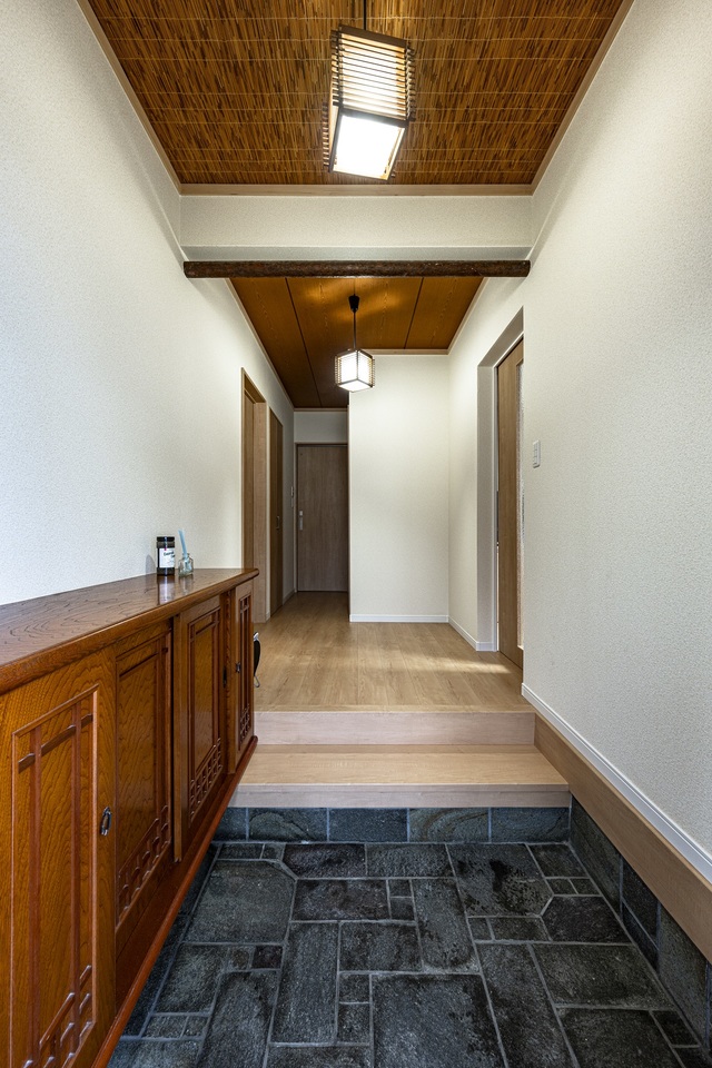 親世帯の玄関は、土間タイルと下足箱、天井の造りはそのまま再利用。広さも変えていませんので、お母さんが住みなれた雰囲気を残しました。既存の良さを残しつつ、明るい室内になるようにフローリングや建具、窓には明るい色を使用。 親世帯の玄関は、土間タイルと下足箱、天井の造りはそのまま再利用。広さも変えていませんので、お母さんが住みなれた雰囲気を残しました。既存の良さを残しつつ、明るい室内になるようにフローリングや建具、窓には明るい色を使用。