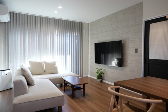 大きな窓から入る光で、いつでも明るく温かみのあるリビング。
バーチカルブラインドを使用することで、天井が高く空間が広く感じます。