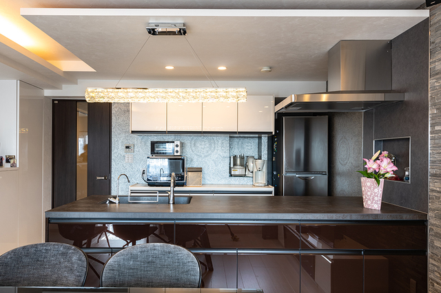 セラミックのキッチン天板の側背面には黒っぽいこだわりクロスを貼りました。