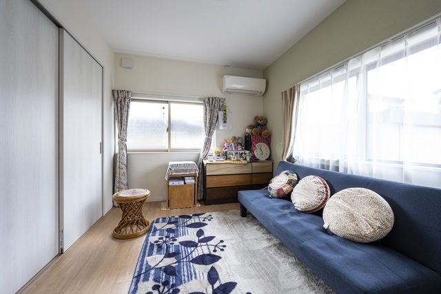 ダイニングキッチンとリビングが分かれていた部屋をひとつにし、ワンルームに。古かったキッチンはシステムキッチンへ変更。
アクセントクロスにはお母さんの好きな薄いグリーンを採用。
断熱対策と家具を置きやすいように、掃出し窓を腰窓に変更した。