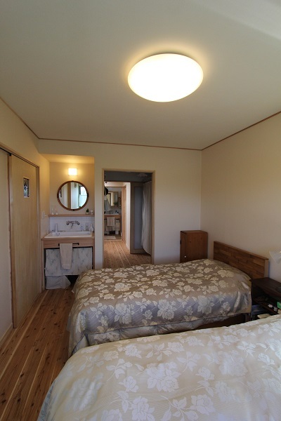 まるでホテルの様な主寝室。一角にある洗面台の鏡は以前玄関にあったものを再利用。