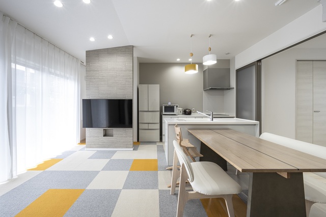 元々は、広縁と和室だった17帖のLDKは天井高が2600あるため、17帖より広く感じられる。
テレビ背面はタイル調のアクセントクロスにし、全体をグレージュでまとめた。キッチンはお子さんの様子が常に見れる様、OPENのセパレーキッチンに。