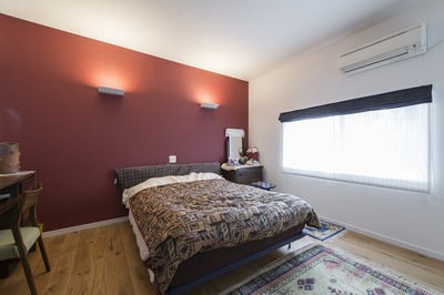 渋い赤とブラウンでまとめた大人のベッドルーム。