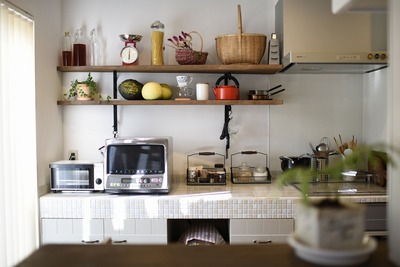 キッチン背面には奥様リクエストの棚とタイル張りの収納を造作。ディスプレイの楽しみも増えた。