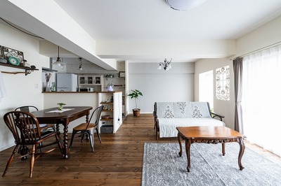 独立型だったキッチンの向きを移動し、洋室の壁を撤去して広げた18.5帖のLDK。塗り壁で仕上げたLDKは、無垢の建具やフローリングをアンティークブラウンでまとめ、 落ち着いた空間を演出。