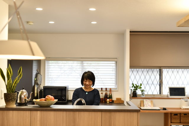 キッチンは念願の対面式にし、立ち上がりを高くした収納カウンターを造作しました。背面の窓には大きな薔薇の木があり、薔薇のシーズンにはバラを楽しめる窓の配置にしました。