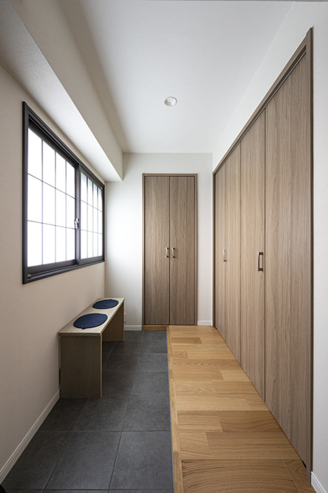 戸建てのように広く明るい玄関。
造作のベンチは靴を履くときだけでなく荷物置きとしても活躍しそう。
内窓には障子デザインを採用することで、落ち着きのある『和』の雰囲気に。