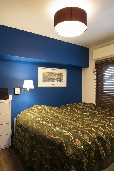 リフォーム最初からイメージいた一面だけ青い寝室を実現。リビングとの間の壁にはお母様が手作りしたステンドガラスを入れてアクセントに。リビング梁を眼立ちたくないように祠をイメージした空間に仕上げた。