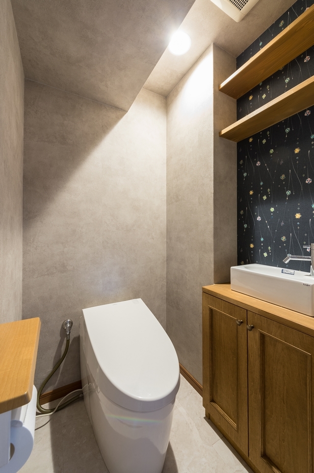 トイレには、手洗いと収納を造作しました。変形した梁を生かして、和でも洋でも合う落ち着いた空間に。