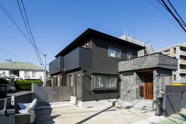 昔ながらの和風の家が、黒とグレーのスタイリッシュな住まいに生まれ変わった。以前は外気にさらされていたポーチを屋内に取り込むことで冷気をシャットアウト。また、2階バルコニーを覆うことで、外からの視線を遮りプライバシーを守る