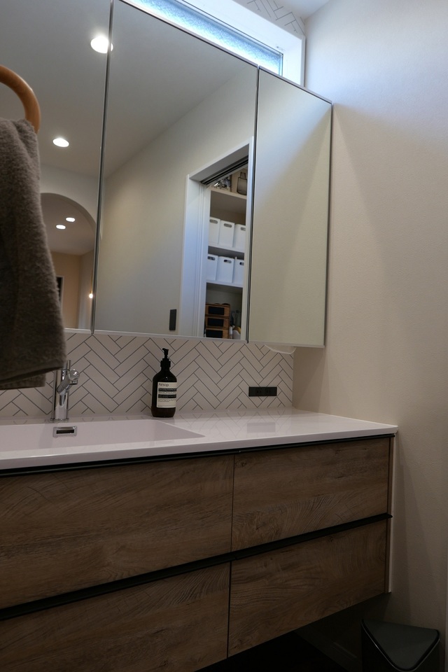 朝の準備で混雑する洗面所は独立にし、脱衣所兼ランドリールームを設けました。
水廻り動線の工夫で、家事も無駄なくスムーズに。
キッチン横のパントリーを挟んで、洗面所、そして脱衣所兼ランドリールームを配置。