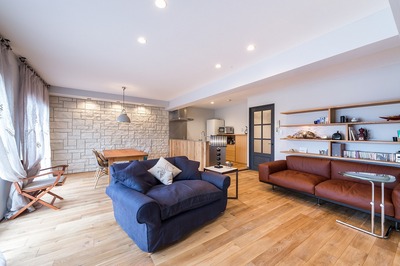 リビング。ダイニング壁には全面タイル。ソファ上の造作棚にはおしゃれにディスプレイ。